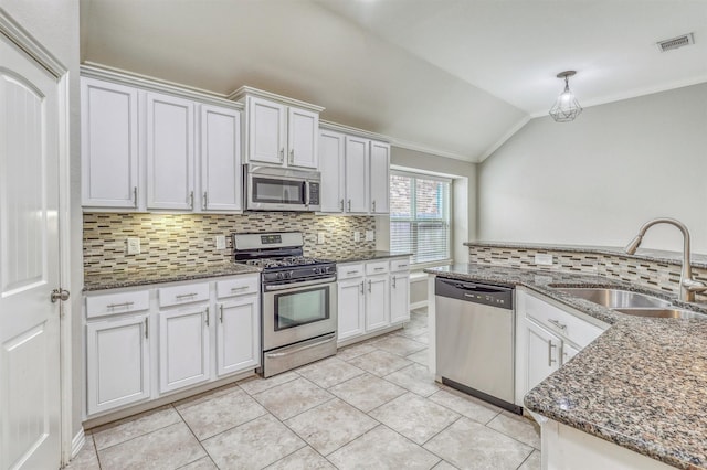 3515 Cactus Field Ln, Katy, TX 77449 - kitchen with appliances with stainless steel finishes, vaulted ceiling, backsplash, ornamental molding, and white cabinets