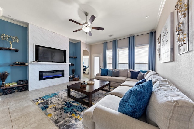 3515 Cactus Field Ln, Katy, TX 77449 - tiled living area with arched walkways, ceiling fan, a high end fireplace, and ornamental molding