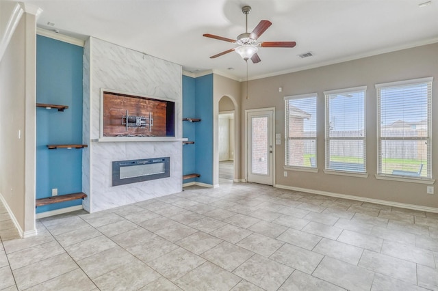 3515 Cactus Field Ln, Katy, TX 77449 - unfurnished living room with a tile fireplace, ceiling fan, tile patterned floors, ornamental molding, and arched walkways