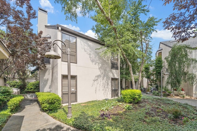 5082 Augusta St, Houston, TX 77007 - view of side of property with stucco siding and a chimney