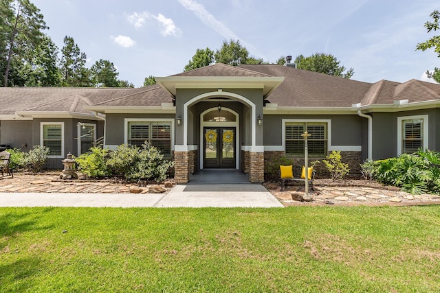 27724 Colapis Dr, Splendora, TX 77372 - view of front of home with french doors, stucco siding, a front lawn, and stone siding
