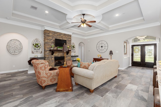27724 Colapis Dr, Splendora, TX 77372 - living area with arched walkways, french doors, a stone fireplace, ceiling fan, and crown molding