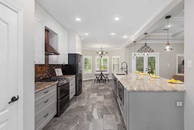 27724 Colapis Dr, Splendora, TX 77372 - kitchen with range with two ovens, recessed lighting, ornamental molding, backsplash, and light stone counters