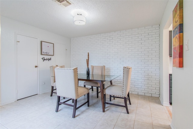 2429 Briarwest Blvd, Houston, TX 77077 - dining area with brick wall, a textured ceiling, and light tile patterned floors