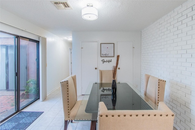 2429 Briarwest Blvd, Houston, TX 77077 - tiled dining area with brick wall and a textured ceiling