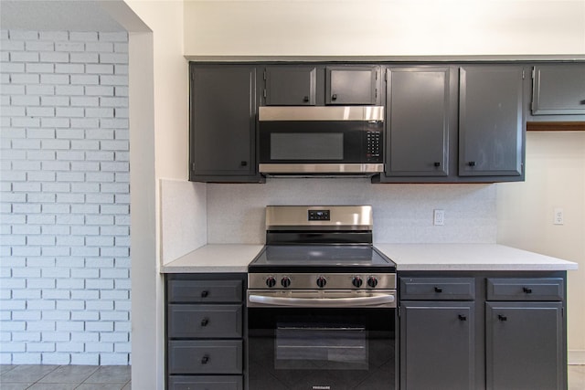 2429 Briarwest Blvd, Houston, TX 77077 - kitchen featuring stainless steel appliances, gray cabinets, light countertops, and tile patterned floors