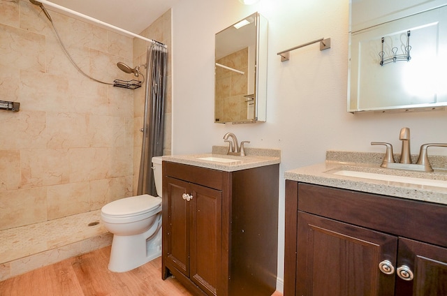 1700 Marilyn St, Rosenberg, TX 77471 - full bathroom featuring two vanities, a tile shower, and wood finished floors