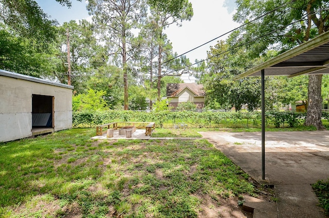 1700 Marilyn St, Rosenberg, TX 77471 - view of yard featuring a patio, a storage unit, and a fire pit
