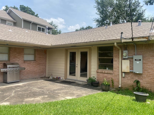 6220 Queenswood Ln, Houston, TX 77008 - entrance to property with french doors, a patio area, a shingled roof, and brick siding