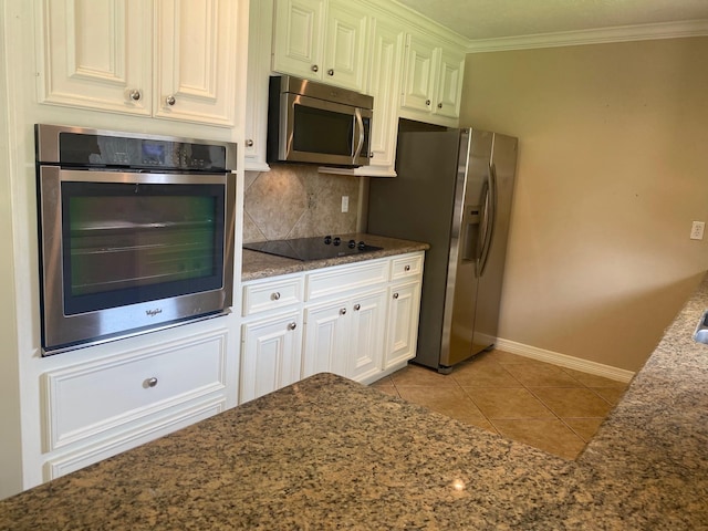 6220 Queenswood Ln, Houston, TX 77008 - kitchen with stainless steel appliances, decorative backsplash, light tile patterned floors, dark stone countertops, and white cabinetry