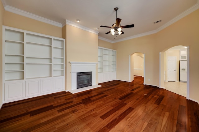 5022 Coral Gables Dr, Houston, TX 77069 - unfurnished living room with ceiling fan, wood finished floors, ornamental molding, arched walkways, and a glass covered fireplace