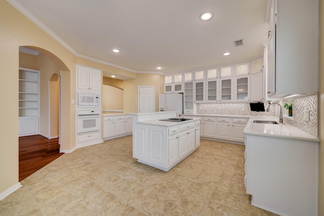 5022 Coral Gables Dr, Houston, TX 77069 - kitchen with white appliances, ornamental molding, arched walkways, white cabinets, and light countertops