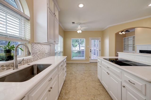 5022 Coral Gables Dr, Houston, TX 77069 - kitchen featuring black electric stovetop, ceiling fan, tasteful backsplash, light countertops, and ornamental molding