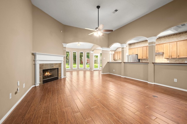 31406 Spica St, Tomball, TX 77375 - unfurnished living room with a ceiling fan, a tile fireplace, wood finished floors, and high vaulted ceiling