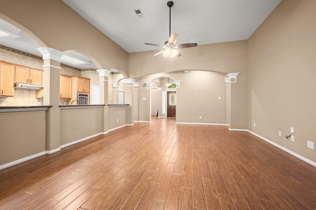 31406 Spica St, Tomball, TX 77375 - unfurnished living room with ceiling fan, light wood finished floors, ornate columns, and arched walkways