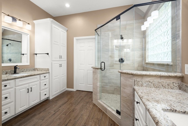 31406 Spica St, Tomball, TX 77375 - bathroom with two vanities, a stall shower, wood finished floors, and recessed lighting