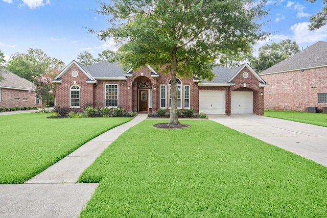 31406 Spica St, Tomball, TX 77375 - traditional home with brick siding, a garage, a front lawn, and concrete driveway