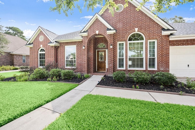 31406 Spica St, Tomball, TX 77375 - view of front facade with brick siding, a front lawn, and an attached garage