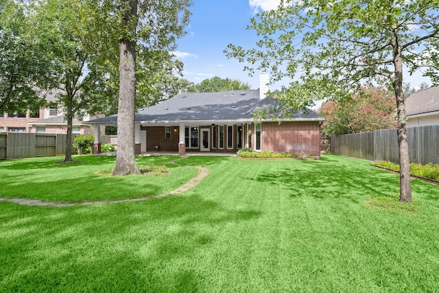 31406 Spica St, Tomball, TX 77375 - back of property with a fenced backyard, brick siding, a chimney, and a patio