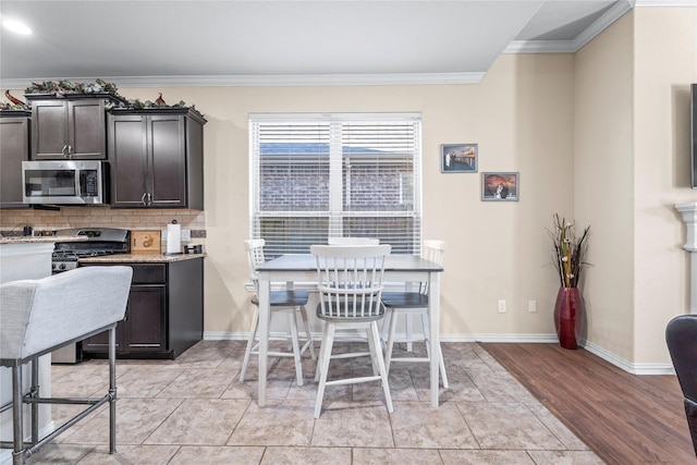 24111 Auburn Woods Ct, Porter, TX 77365 - kitchen featuring appliances with stainless steel finishes, crown molding, backsplash, light wood-style flooring, and dark brown cabinets