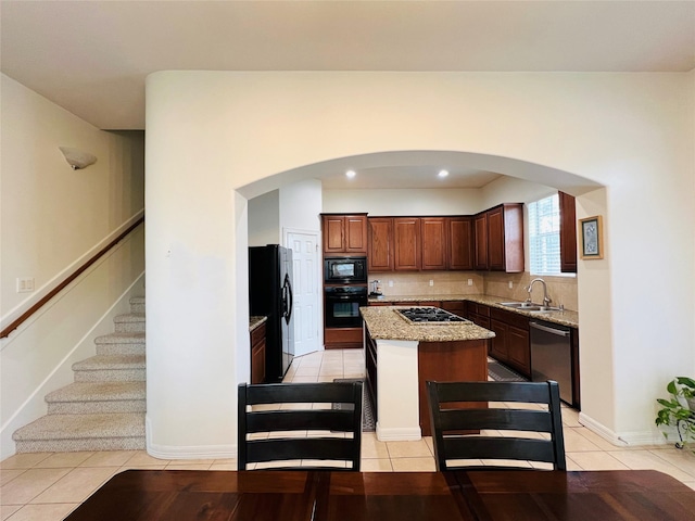 8018 Stoneyway Dr, Houston, TX 77040 - kitchen with black appliances, a center island, light tile patterned floors, light stone counters, and backsplash