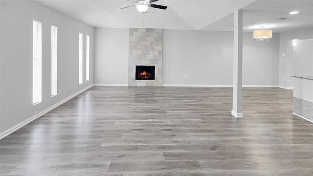 2414 Stillmeadow Dr, Missouri City, TX 77489 - unfurnished living room featuring a ceiling fan, wood finished floors, a tile fireplace, and vaulted ceiling