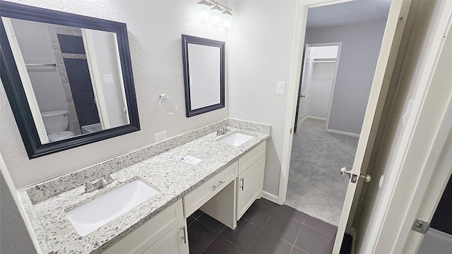 2414 Stillmeadow Dr, Missouri City, TX 77489 - bathroom with double vanity, tile patterned flooring, and a textured wall