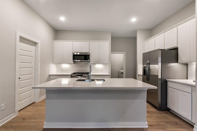 2532 Allegretto Sea Dr, Katy, TX 77493 - kitchen with appliances with stainless steel finishes, light countertops, white cabinetry, a center island with sink, and recessed lighting