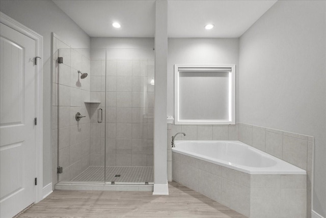 5000 Boreas Dr, Alvin, TX 77511 - full bathroom featuring a bath, a stall shower, wood finished floors, and recessed lighting