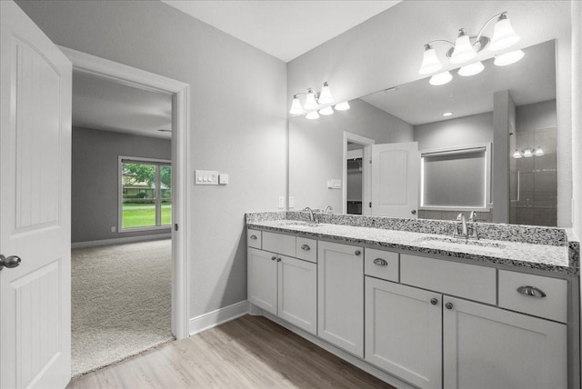5000 Boreas Dr, Alvin, TX 77511 - bathroom featuring double vanity, a chandelier, wood finished floors, and a tile shower