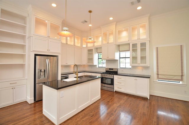 1605 Cohn St, Houston, TX 77007 - kitchen featuring appliances with stainless steel finishes, dark countertops, ornamental molding, white cabinetry, and decorative light fixtures