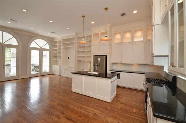 1605 Cohn St, Houston, TX 77007 - kitchen with stainless steel appliances, dark countertops, ornamental molding, open shelves, and white cabinetry
