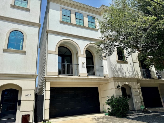 1605 Cohn St, Houston, TX 77007 - view of property with a garage, stucco siding, a balcony, and driveway