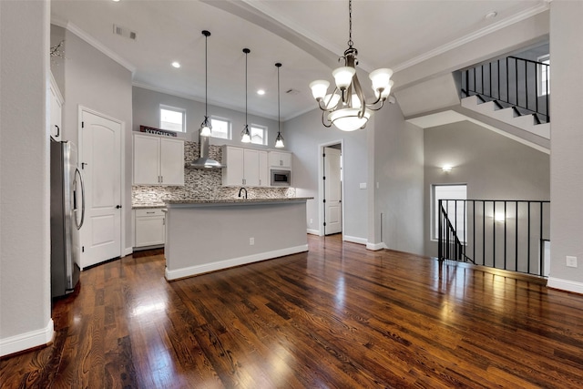 1025 W 21st St Unit C, Houston, TX 77008 - kitchen with appliances with stainless steel finishes, wall chimney exhaust hood, crown molding, white cabinetry, and dark wood-style floors