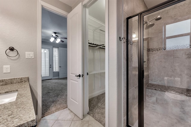 1025 W 21st St Unit C, Houston, TX 77008 - full bathroom featuring a stall shower, tile patterned flooring, a spacious closet, ceiling fan, and a textured wall