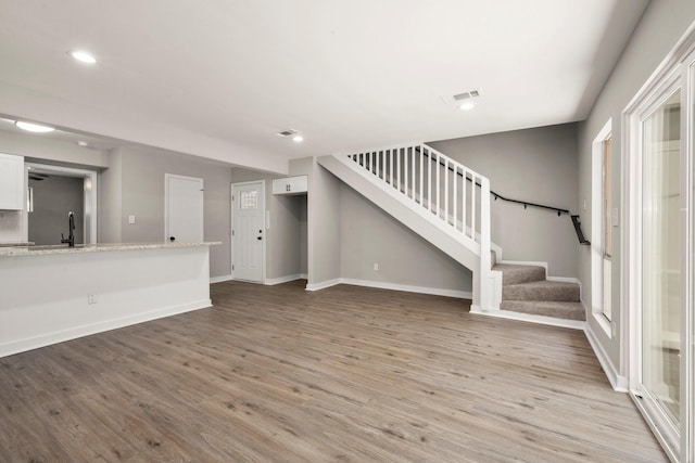 116 Harbour Ln, Coldspring, TX 77331 - unfurnished living room featuring stairs, light wood-style flooring, and recessed lighting