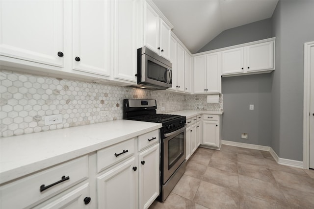 10166 Hidden Creek Falls Ln, Brookshire, TX 77423 - kitchen featuring appliances with stainless steel finishes, tasteful backsplash, vaulted ceiling, white cabinetry, and light stone counters