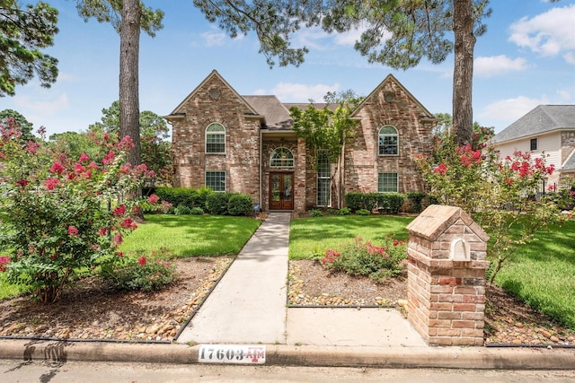 17603 Hidden Forest Dr, Spring, TX 77379 - traditional-style house with a front yard, brick siding, and a shingled roof