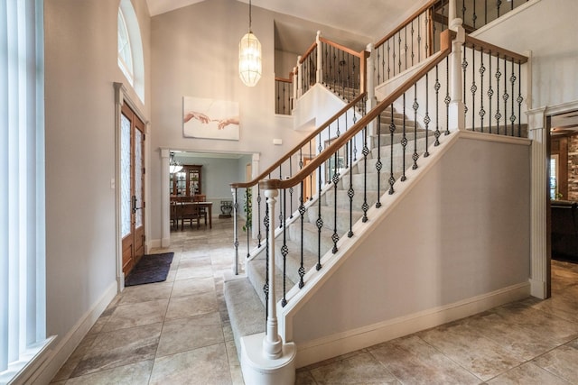 17603 Hidden Forest Dr, Spring, TX 77379 - stairs with a chandelier, plenty of natural light, a towering ceiling, and tile patterned flooring
