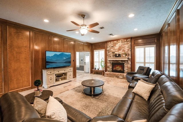 17603 Hidden Forest Dr, Spring, TX 77379 - living room featuring a ceiling fan, wood walls, a brick fireplace, a textured ceiling, and recessed lighting