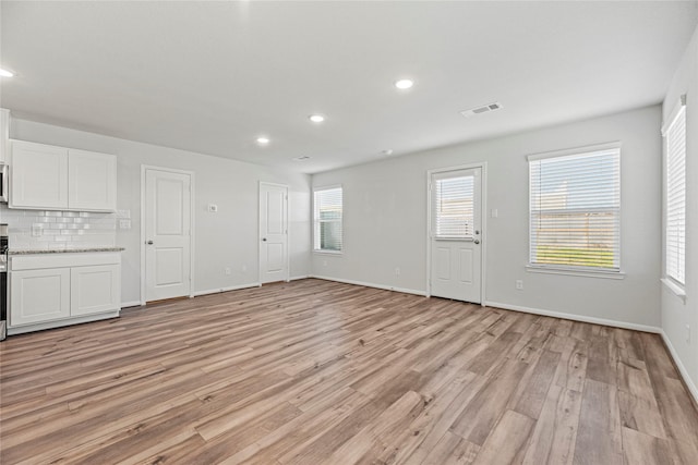 5263 Shallowhurst Ln, Katy, TX 77449 - unfurnished living room with light wood-style flooring and recessed lighting