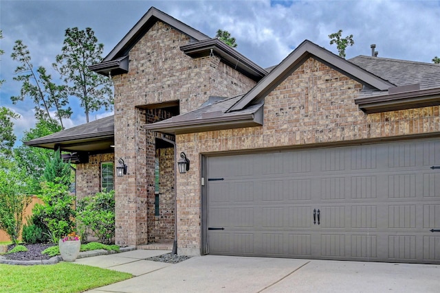 3854 Fleetwood Falls Ln, Spring, TX 77386 - view of front of house with brick siding, a garage, a shingled roof, and driveway