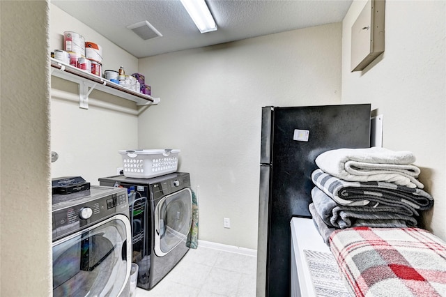 3854 Fleetwood Falls Ln, Spring, TX 77386 - laundry area featuring washing machine and dryer, light tile patterned floors, and a textured ceiling