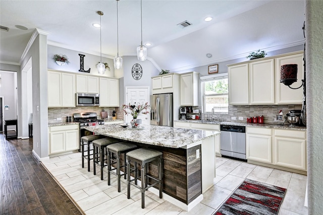 3854 Fleetwood Falls Ln, Spring, TX 77386 - kitchen featuring appliances with stainless steel finishes, crown molding, a breakfast bar area, a center island, and backsplash