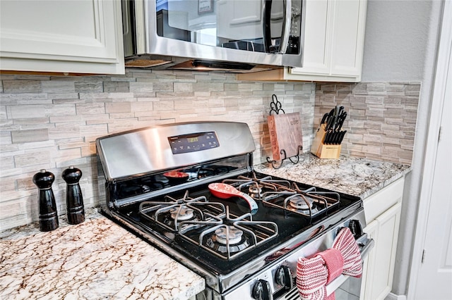 3854 Fleetwood Falls Ln, Spring, TX 77386 - kitchen with stainless steel appliances, white cabinetry, backsplash, and light stone countertops