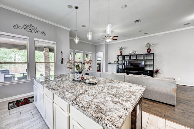 3854 Fleetwood Falls Ln, Spring, TX 77386 - kitchen with white cabinets, ornamental molding, light stone counters, hanging light fixtures, and a ceiling fan