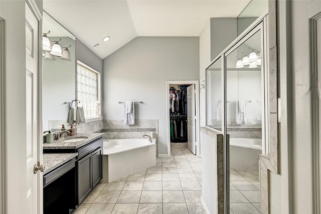 3854 Fleetwood Falls Ln, Spring, TX 77386 - full bathroom featuring a bath, vanity, lofted ceiling, a walk in closet, and a stall shower