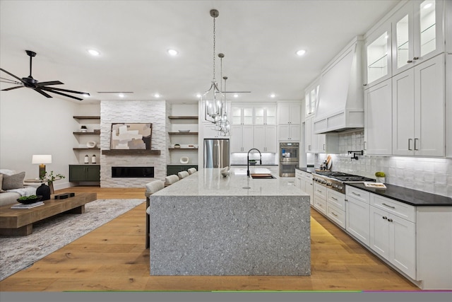 431 W 30th St, Houston, TX 77018 - kitchen featuring appliances with stainless steel finishes, custom exhaust hood, white cabinetry, tasteful backsplash, and recessed lighting