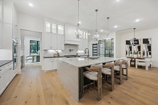 431 W 30th St, Houston, TX 77018 - kitchen with a chandelier, light wood-type flooring, decorative backsplash, white cabinets, and recessed lighting