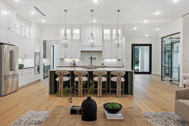 431 W 30th St, Houston, TX 77018 - kitchen featuring appliances with stainless steel finishes, backsplash, a chandelier, glass insert cabinets, and white cabinets